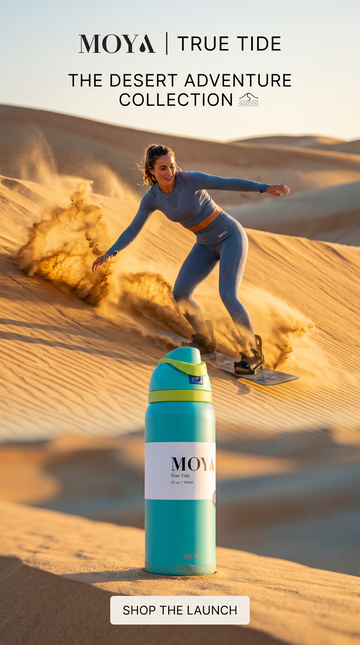 Person sandboarding in the desert with a Moya water bottle in the foreground